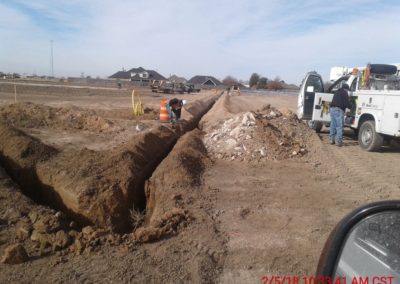 Fuller & Sons Construction workers with pickup truck next to a trench.